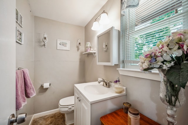 bathroom featuring tile patterned flooring, vanity, and toilet