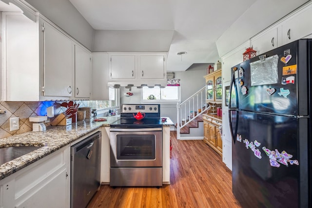 kitchen featuring light wood-type flooring, light stone counters, tasteful backsplash, white cabinets, and stainless steel appliances