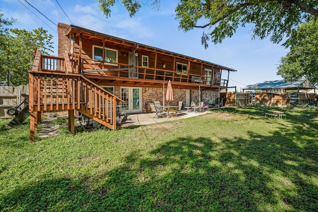 back of property with a lawn and a patio