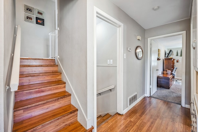 staircase with hardwood / wood-style floors