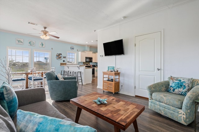 living room featuring crown molding, dark hardwood / wood-style flooring, and ceiling fan