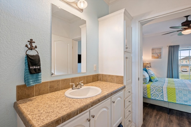 bathroom featuring ornamental molding, vanity, hardwood / wood-style floors, and ceiling fan