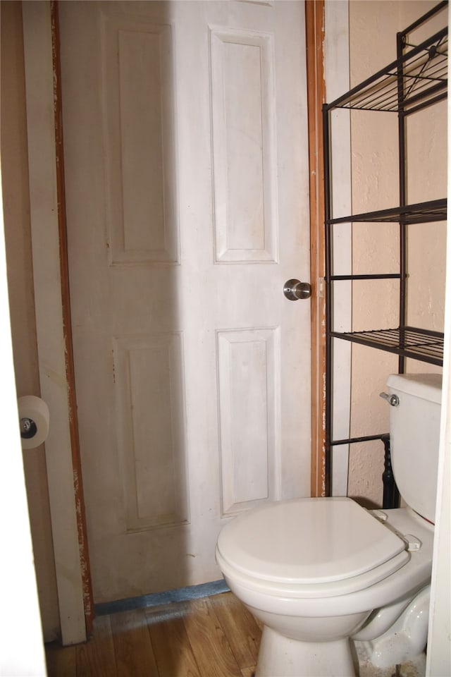 bathroom with hardwood / wood-style floors and toilet