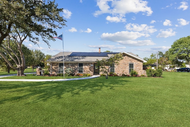 single story home featuring solar panels and a front yard