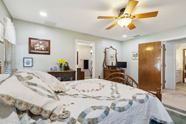 bedroom with ensuite bath, light colored carpet, and ceiling fan