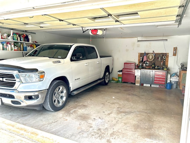 garage featuring a garage door opener, a workshop area, and a carport