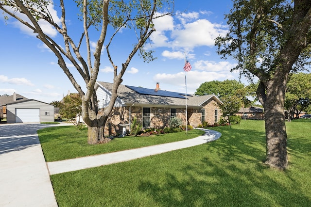 ranch-style house featuring a garage, a front lawn, and an outbuilding