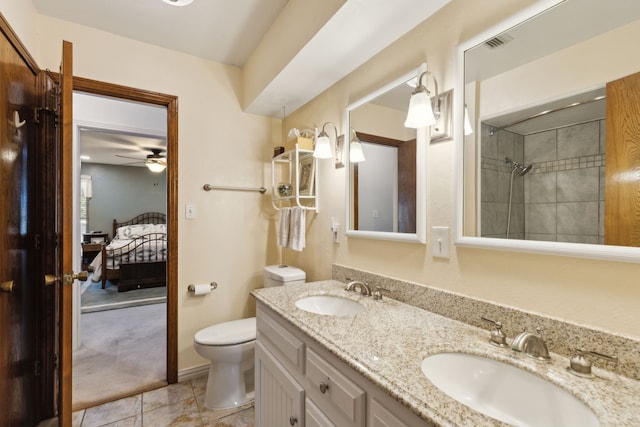 bathroom featuring ceiling fan, toilet, tiled shower, vanity, and tile patterned flooring