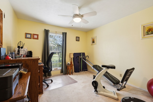 carpeted home office featuring ceiling fan