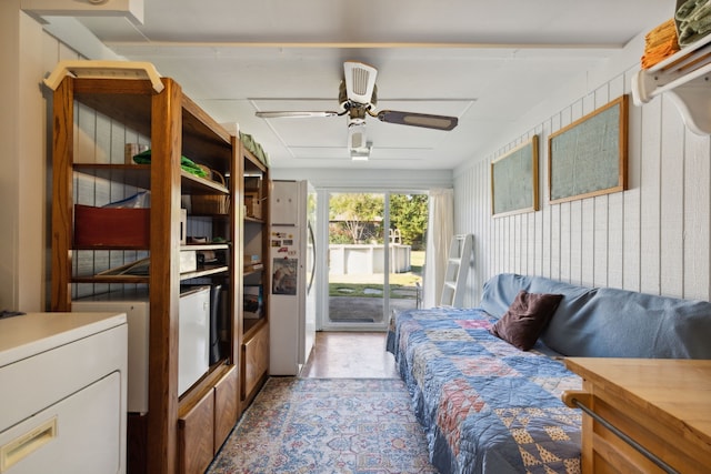 bedroom featuring white fridge, access to exterior, and ceiling fan