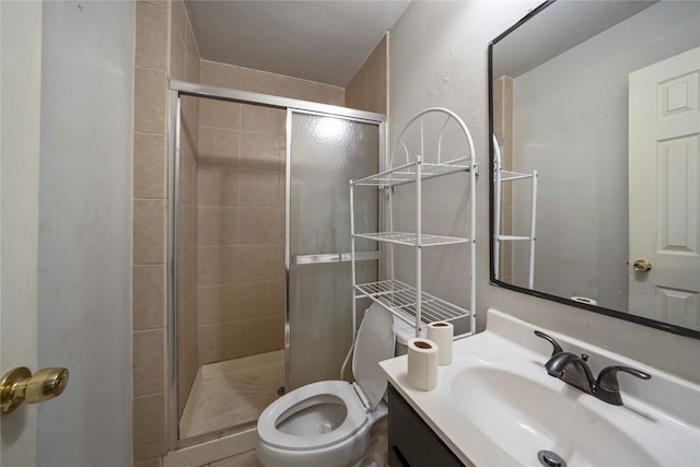 bathroom with a textured ceiling, vanity, toilet, and walk in shower