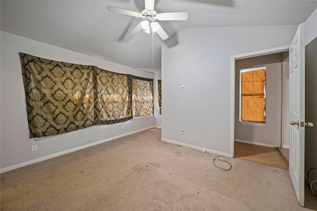 carpeted empty room featuring ceiling fan and vaulted ceiling