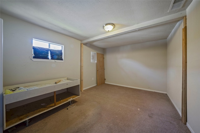 unfurnished bedroom with a textured ceiling and light carpet