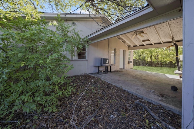 view of side of home featuring ceiling fan and a patio area