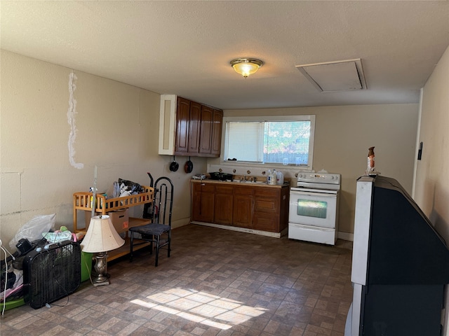 kitchen with a textured ceiling and white range with electric cooktop