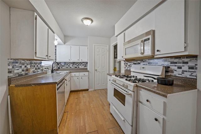 3525 Emerald Dr, Mesquite, TX 75150 - kitchen with white appliances, tasteful backsplash, light wood-style flooring, white cabinets, and dark countertops