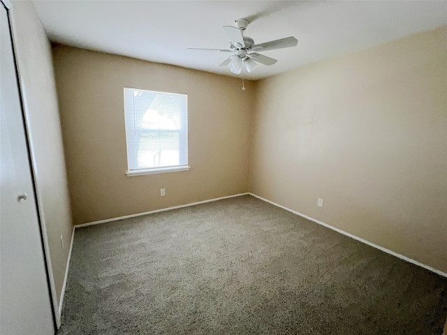 carpeted spare room featuring ceiling fan