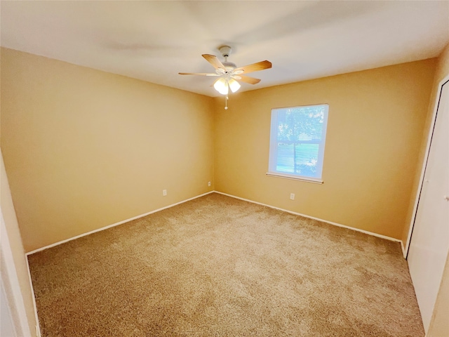 carpeted spare room featuring ceiling fan