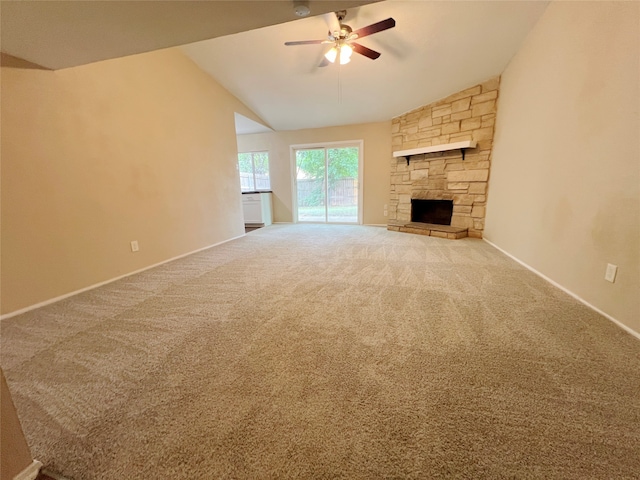 unfurnished living room with ceiling fan, carpet flooring, vaulted ceiling, and a stone fireplace