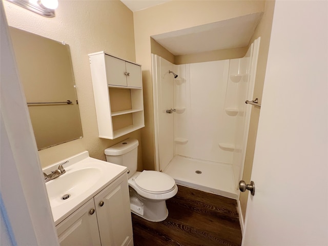 bathroom with a shower, vanity, toilet, and hardwood / wood-style flooring