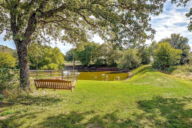 view of property's community with a yard and a water view