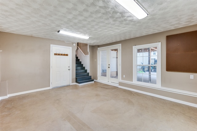 basement featuring french doors and a textured ceiling