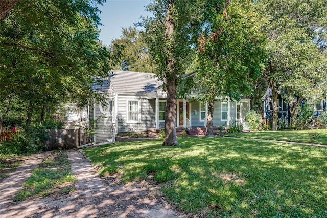 view of property hidden behind natural elements featuring a front yard