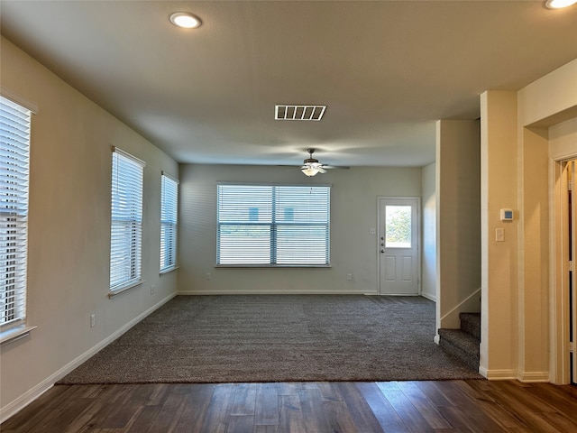 unfurnished living room featuring ceiling fan and dark hardwood / wood-style flooring