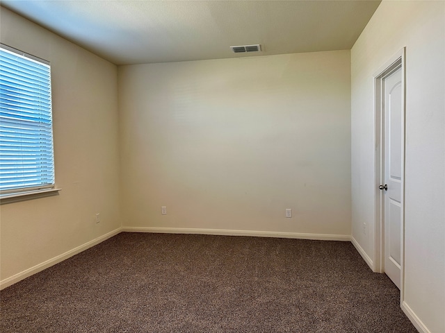 empty room featuring dark colored carpet