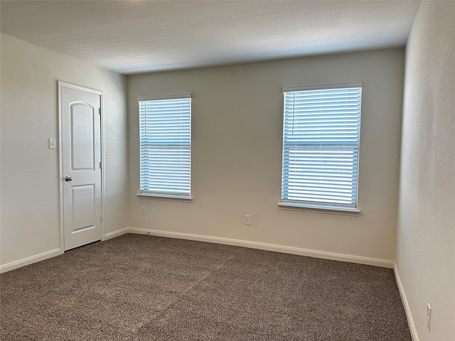 empty room featuring dark carpet