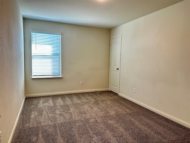 empty room featuring dark colored carpet