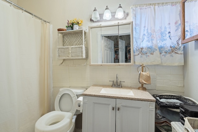 bathroom with decorative backsplash, vanity, and toilet