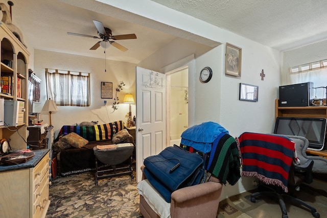 living room with a textured ceiling and ceiling fan