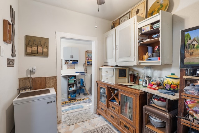 kitchen with fridge, white cabinetry, and ceiling fan