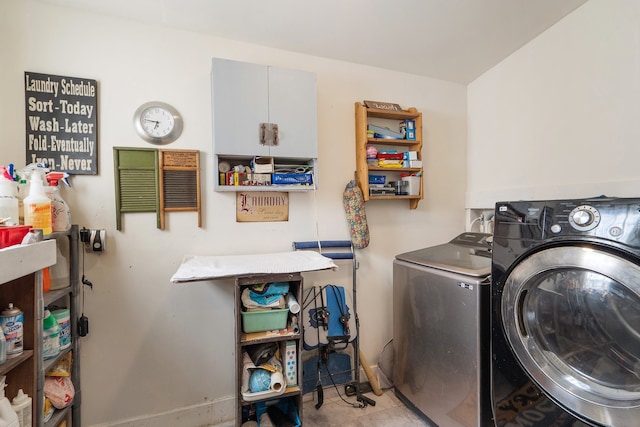 washroom with cabinets, light tile patterned floors, and washing machine and clothes dryer