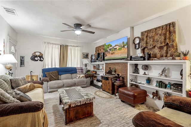 living room with ceiling fan and a textured ceiling