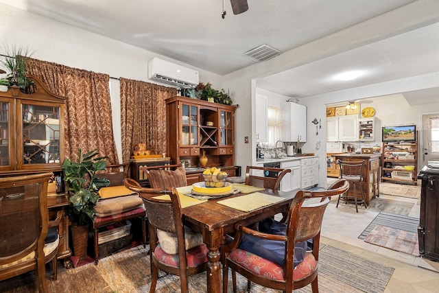 dining area with ceiling fan, sink, and a wall mounted air conditioner