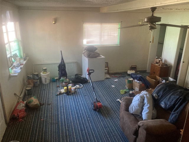 miscellaneous room with ceiling fan, carpet floors, and a textured ceiling