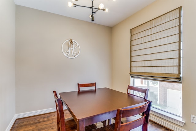 dining space featuring an inviting chandelier and dark wood-type flooring