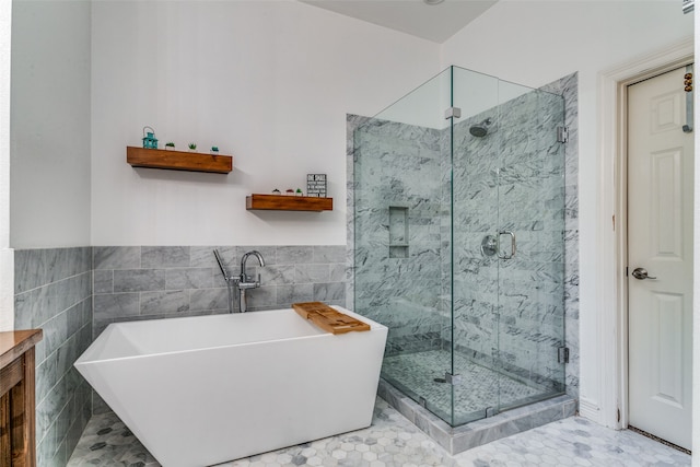 bathroom with tile walls, shower with separate bathtub, tile patterned floors, and vanity