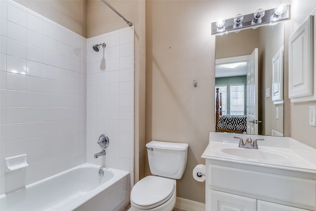 full bathroom featuring tiled shower / bath, vanity, and toilet