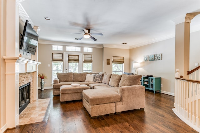 living room with a fireplace, dark hardwood / wood-style floors, ceiling fan, and plenty of natural light