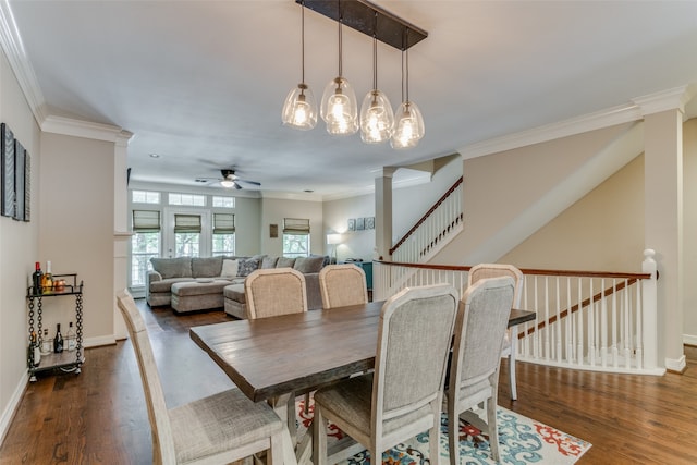 dining area with ceiling fan, decorative columns, dark hardwood / wood-style flooring, and crown molding