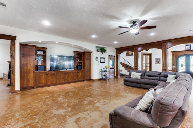 living room with ceiling fan, a textured ceiling, and french doors