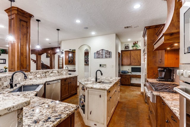 kitchen with pendant lighting, sink, a center island with sink, and stainless steel appliances