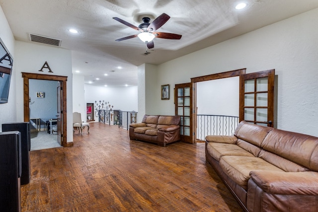 living room featuring ceiling fan, hardwood / wood-style flooring, and a textured ceiling