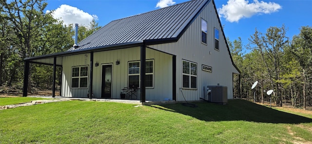 back of house with a yard and central AC