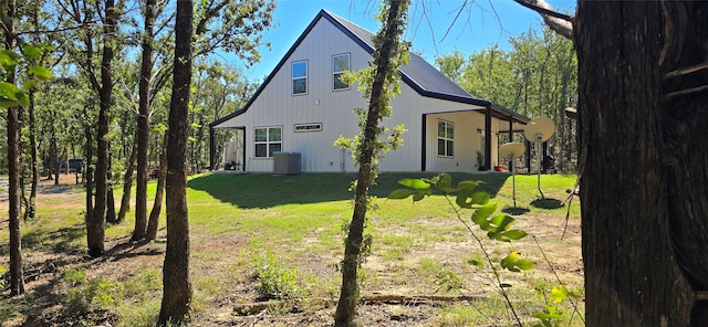 view of side of home with central air condition unit and a yard