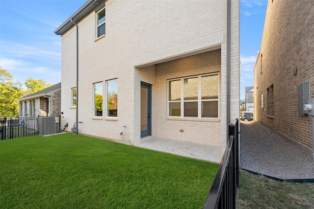 back of house with a lawn, a patio area, and central air condition unit