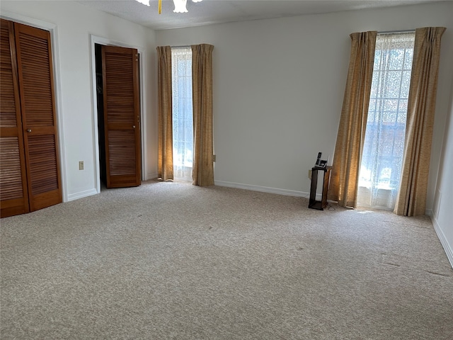 unfurnished bedroom featuring two closets, carpet, and a textured ceiling